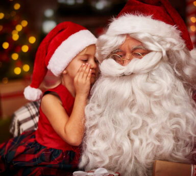 enfant chuchotant dans l'oreille du père Noël