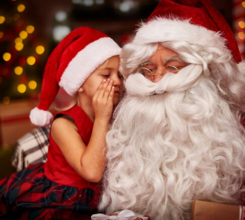 enfant chuchotant dans l'oreille du père Noël