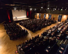 vue en hauteur d'une conférence avec public dans les gradins de la salle Le Ponant